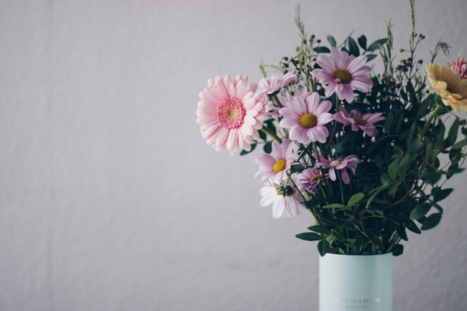 A vase filled with pink flowers on top of a table.