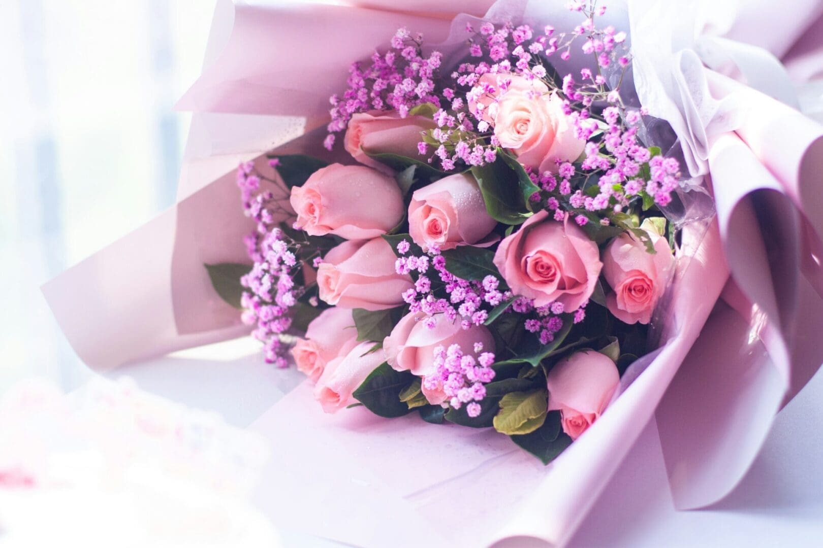 A bouquet of pink roses and purple flowers.