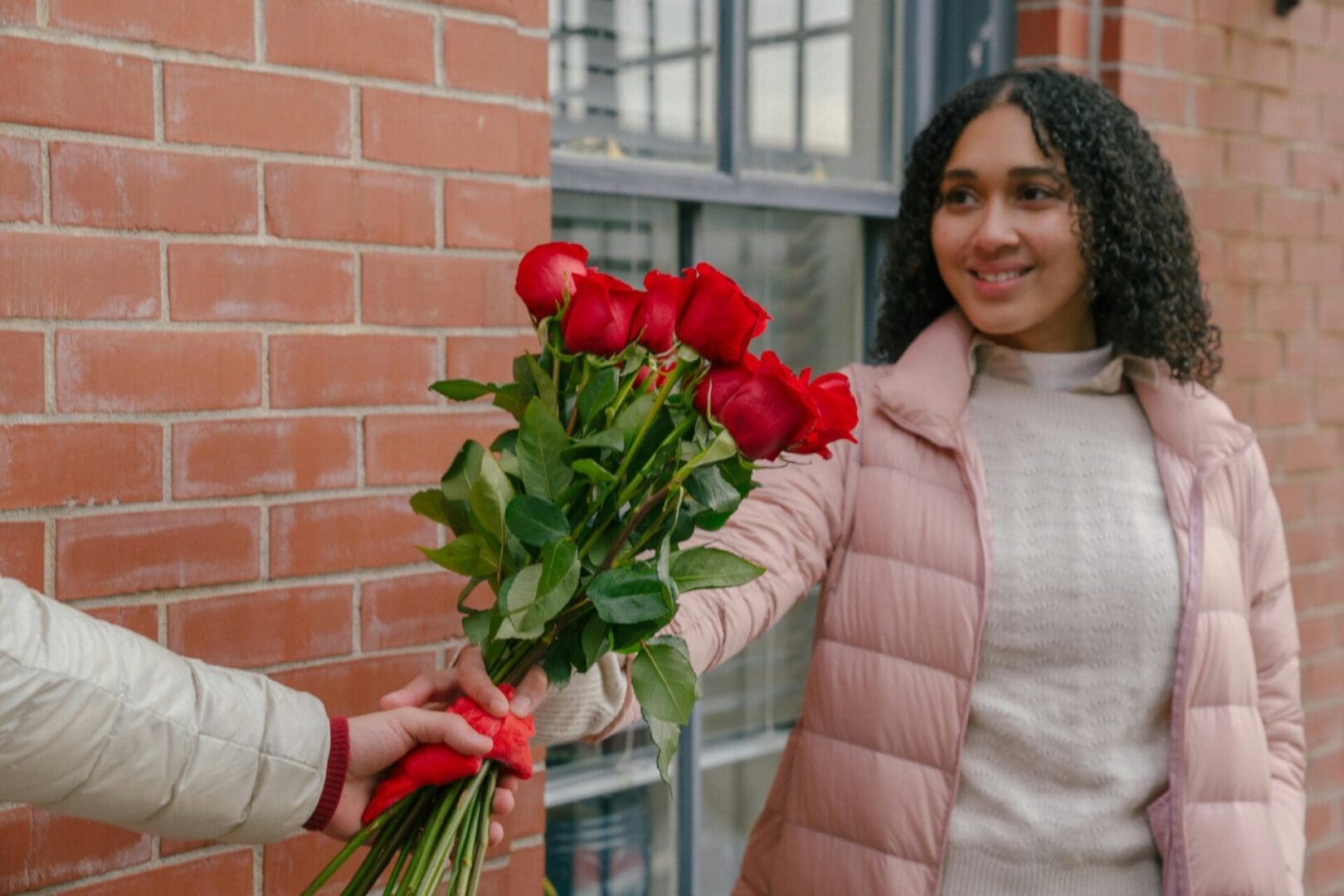 A woman is giving roses to someone else