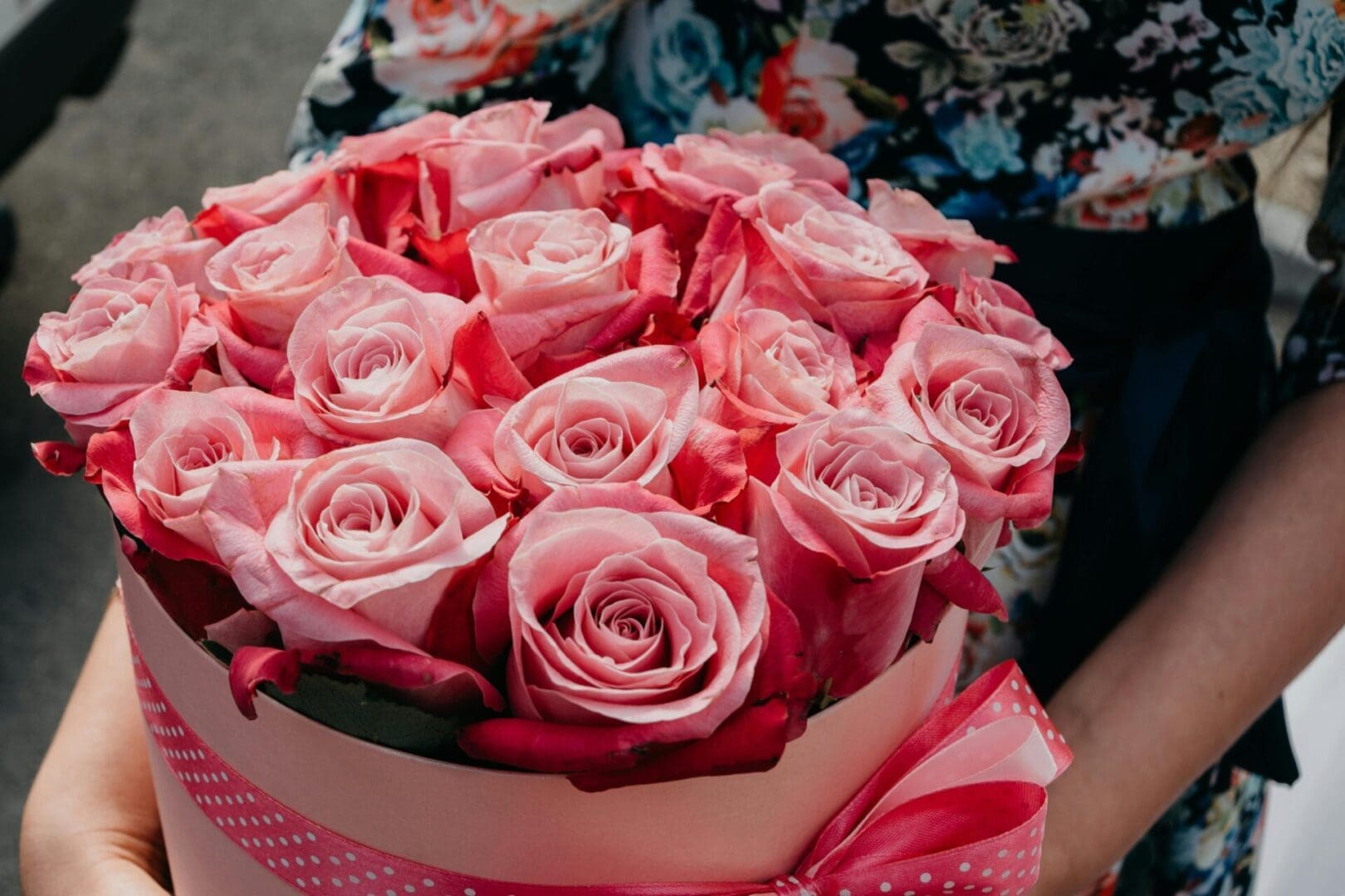 A pink bouquet of roses in a box.