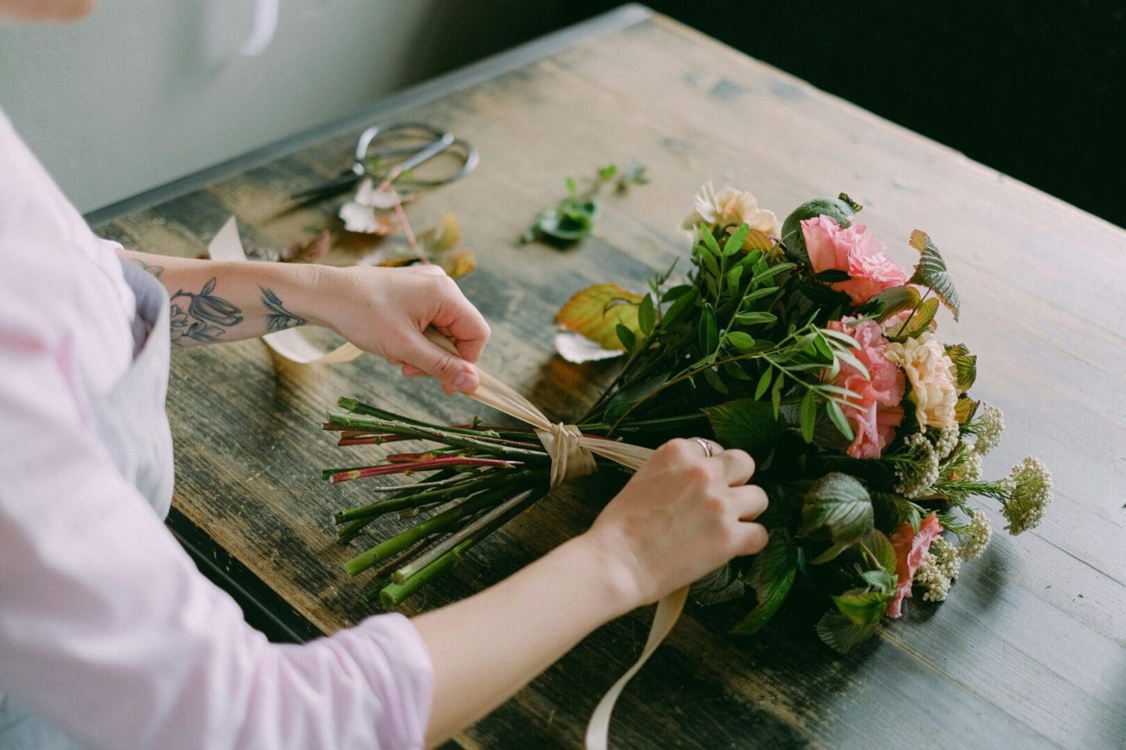 A person is making flowers on a table.